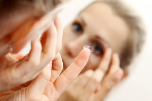 close up of a woman putting contact lens in her eye